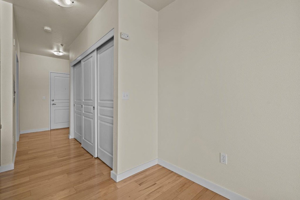 a bedroom with a door to a closet and a hard wood floor