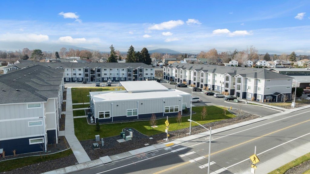 A view of a road with a yellow sign and a building in the background.
