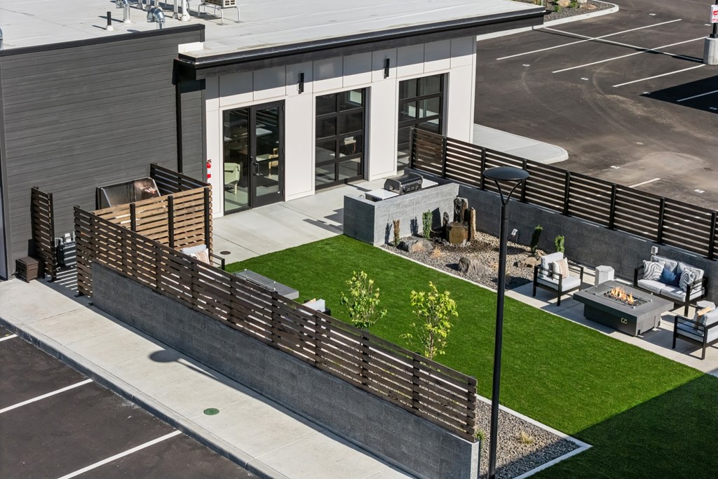 A modern building with a wooden fence and a small garden in front.