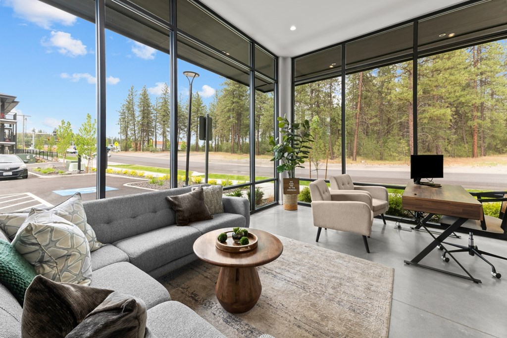 A modern living room with a large grey sofa and a wooden coffee table.