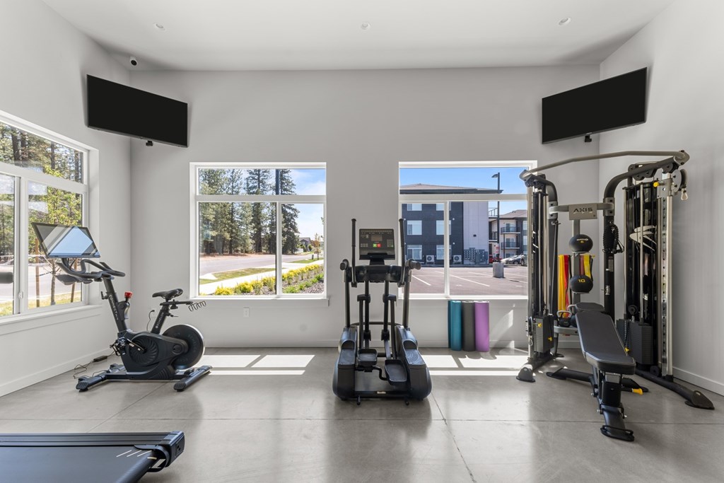 A spacious home gym with a variety of equipment including a treadmill, stationary bike, and weight machines.