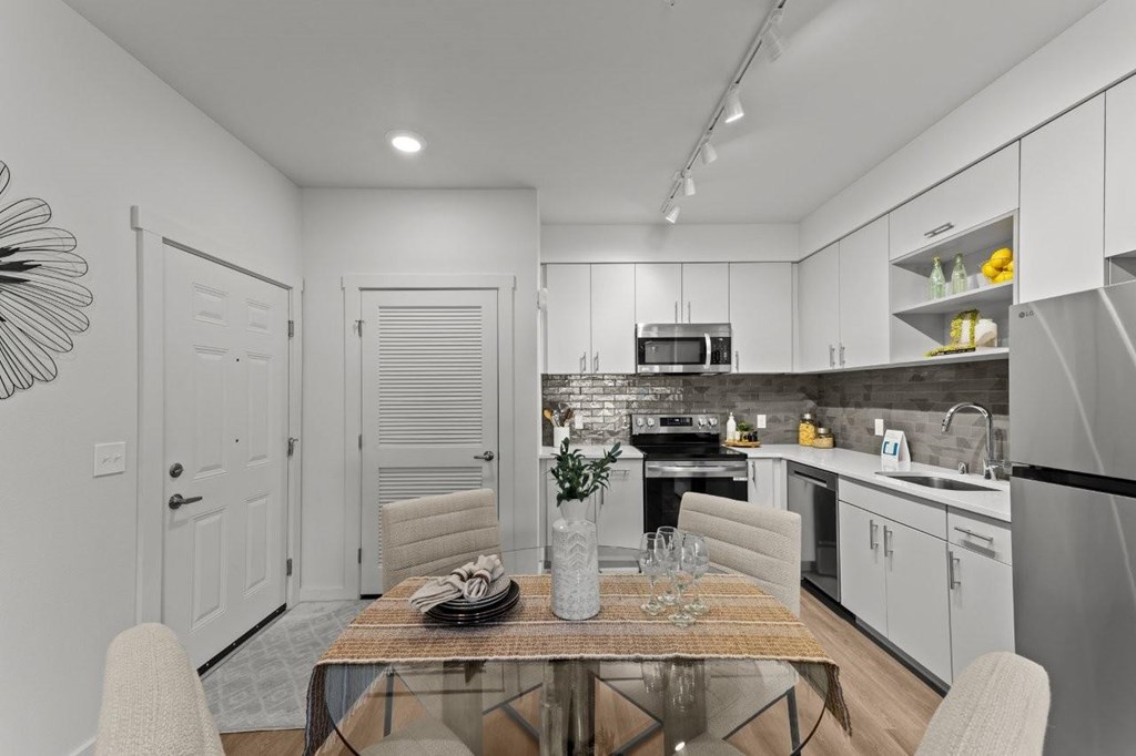 A modern kitchen with a dining table set for two.