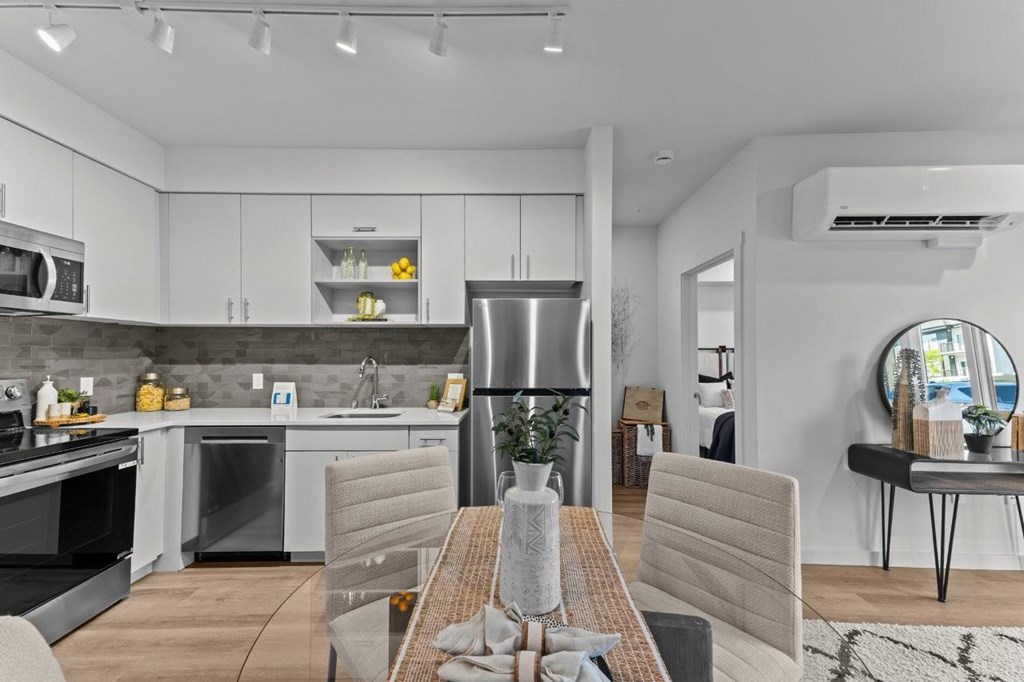 A modern kitchen with a dining table set for two.