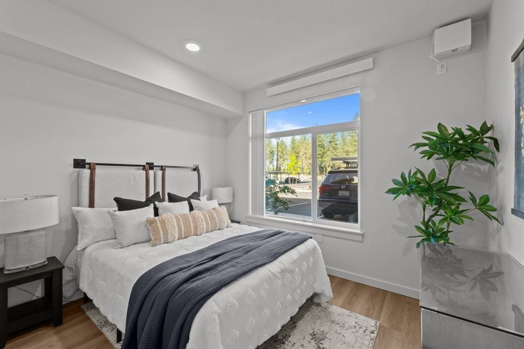 A bedroom with a large bed and a window overlooking a street.