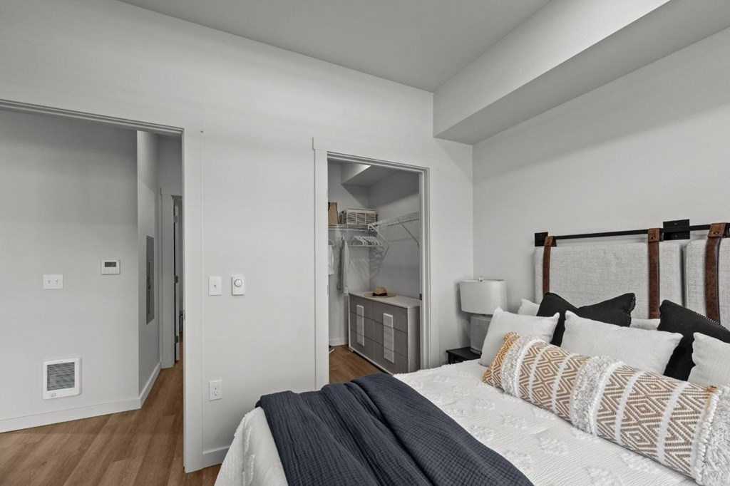 A bedroom with a bed, pillows, and a nightstand.