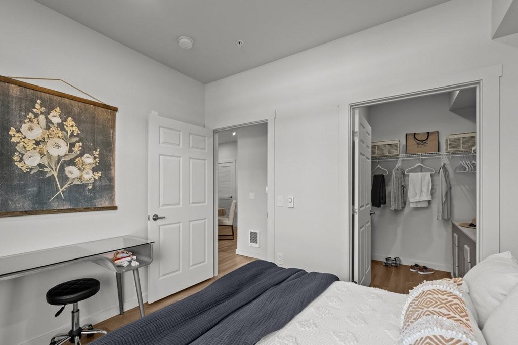 A bedroom with a large bed and a painting on the wall.