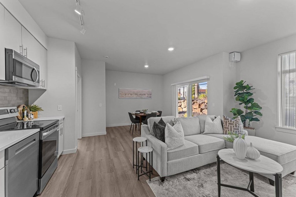 A modern kitchen with a dining area and a living room.