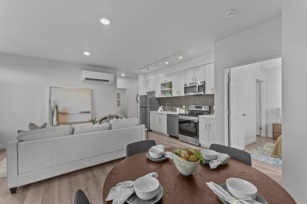 A modern kitchen and living room with a dining table set for a meal.