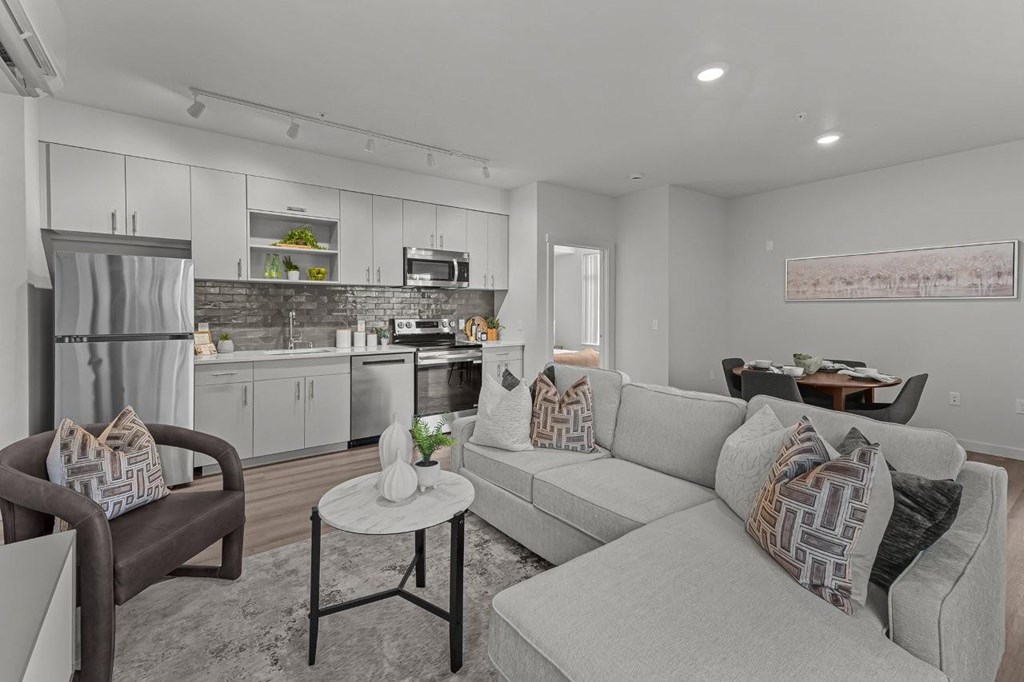 A modern living room with a grey couch and a brown chair.