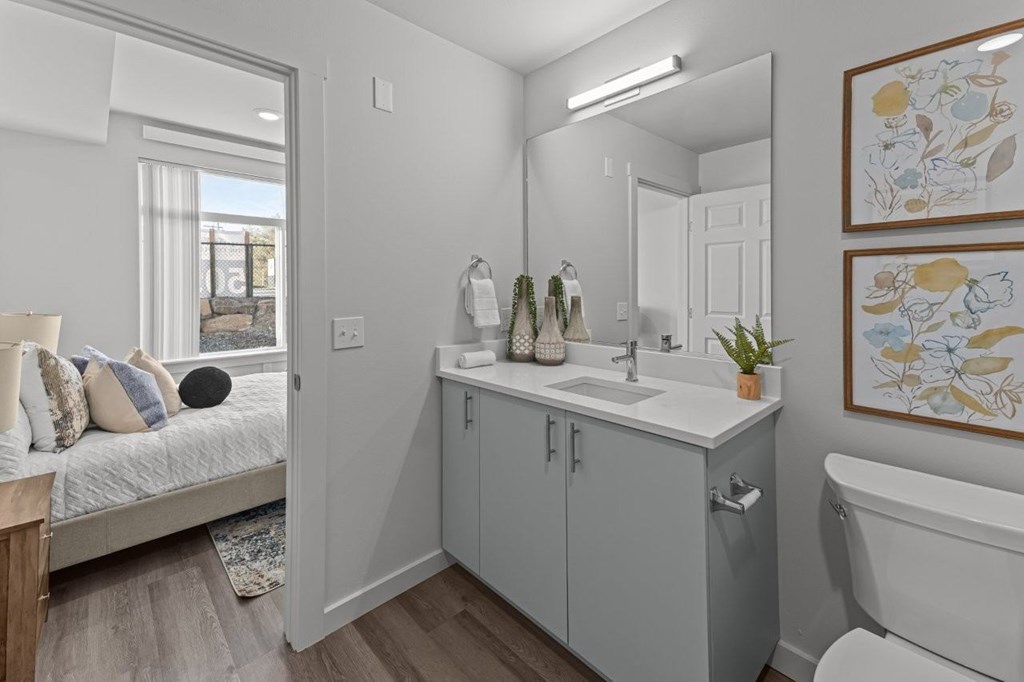 A bathroom with a white tub, sink, and a mirror.