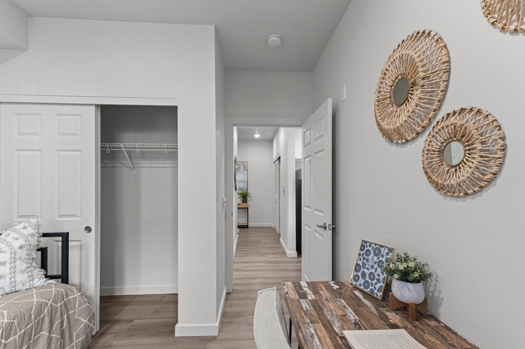 A white hallway with a wooden table and two woven wall hangings.