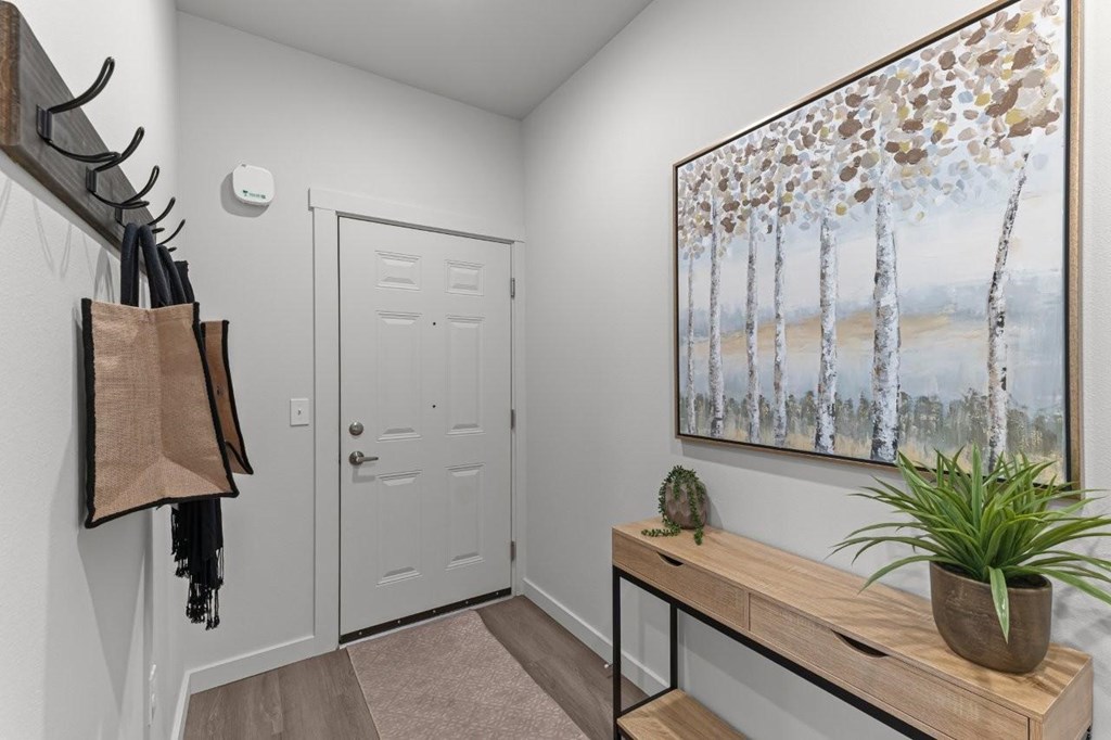 A hallway with a painting of birch trees on the wall.