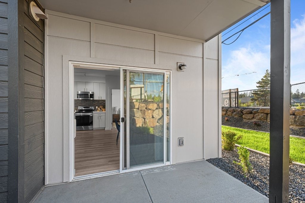 A modern house with a glass door leading to a kitchen.