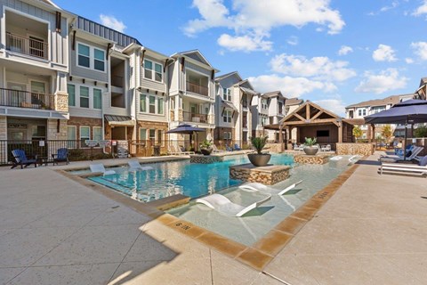 A large swimming pool in front of apartment buildings.