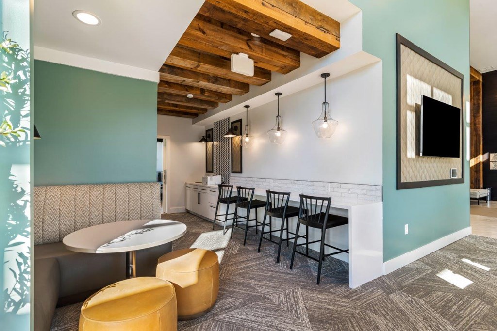 A room with a table and chairs and a television.