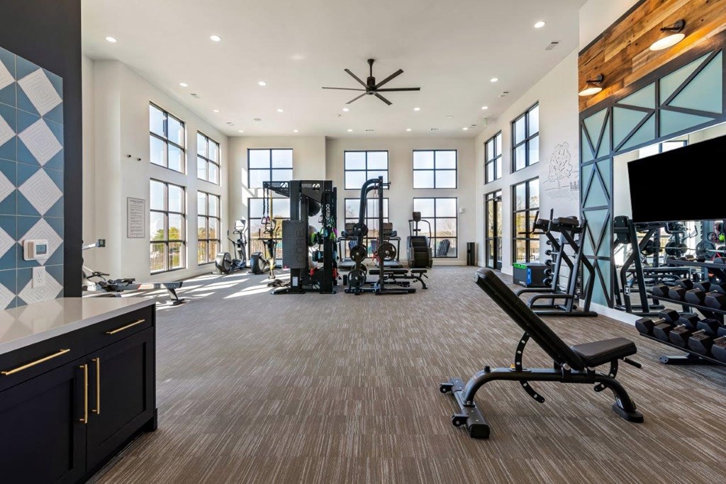 A gym with a variety of equipment including a bench press.