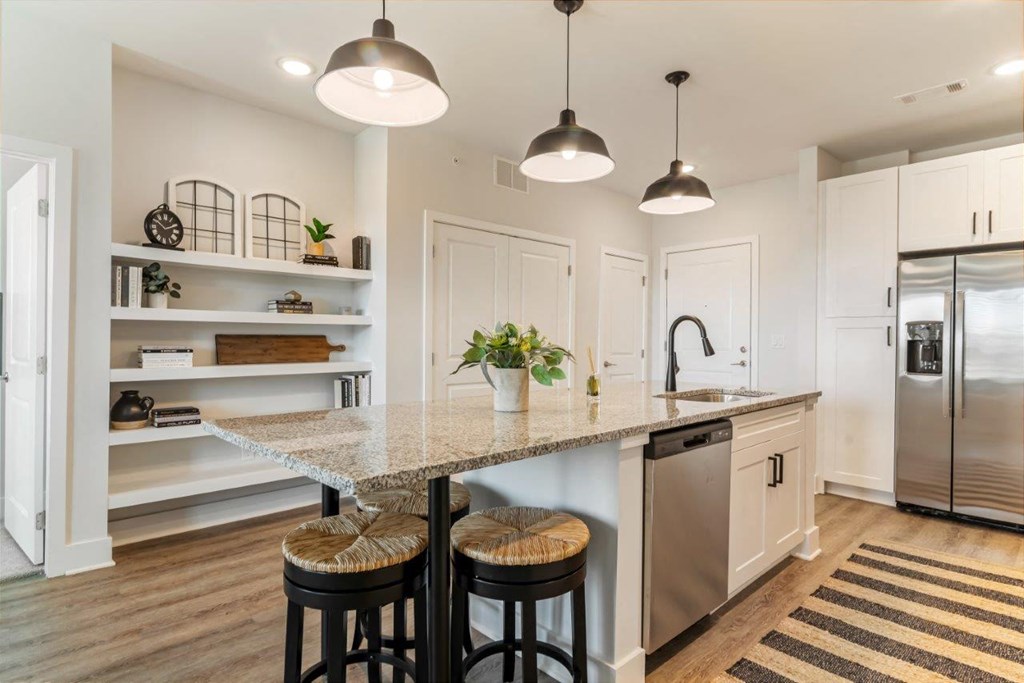 A kitchen with a granite countertop and stainless steel appliances.