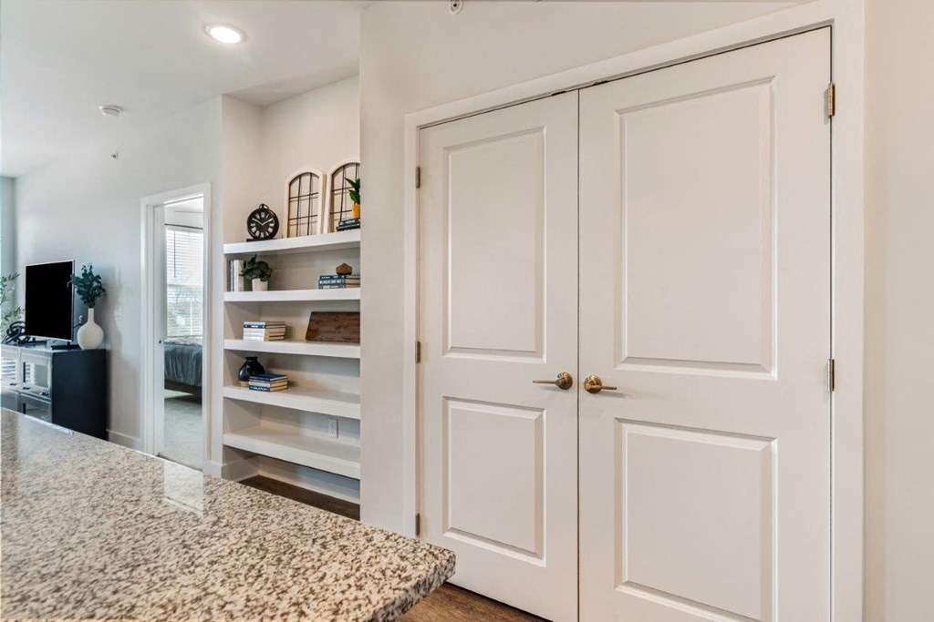 A white kitchen with a granite counter top and a white cabinet.