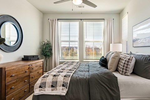 A bedroom with a large bed and a mirror on the wall.