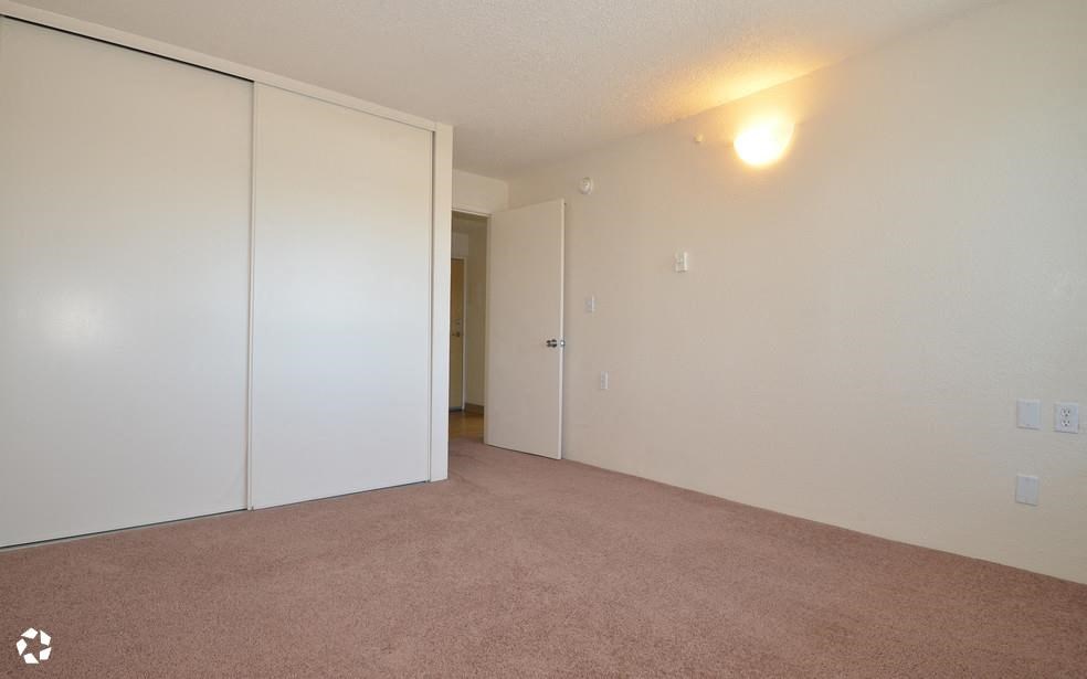an empty living room with white walls and doors