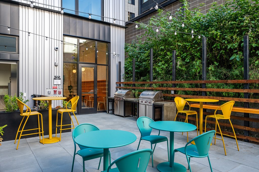 MERX Slabtown patio with tables and chairs is surrounded by plants.