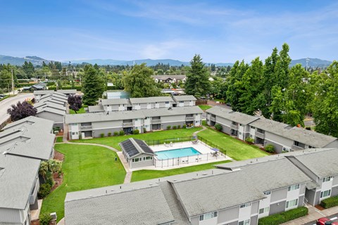 Apartment complex with a pool and green lawns.