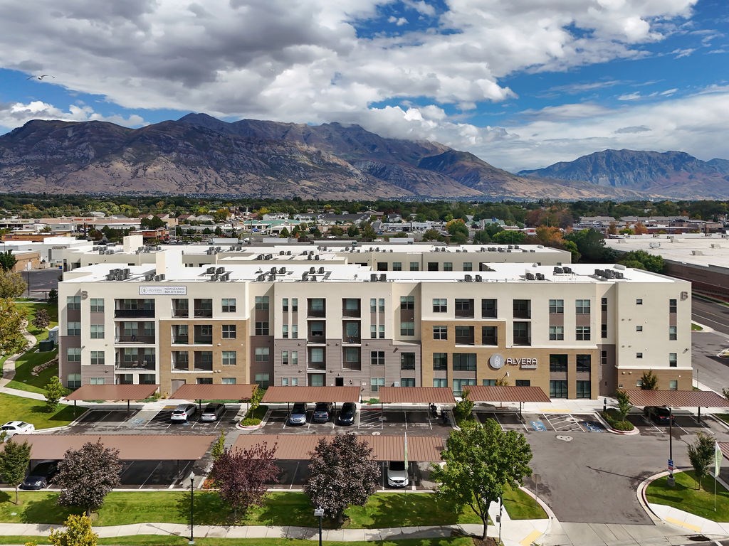 Alvera at the Meadows  A large building with a parking lot in front of it.