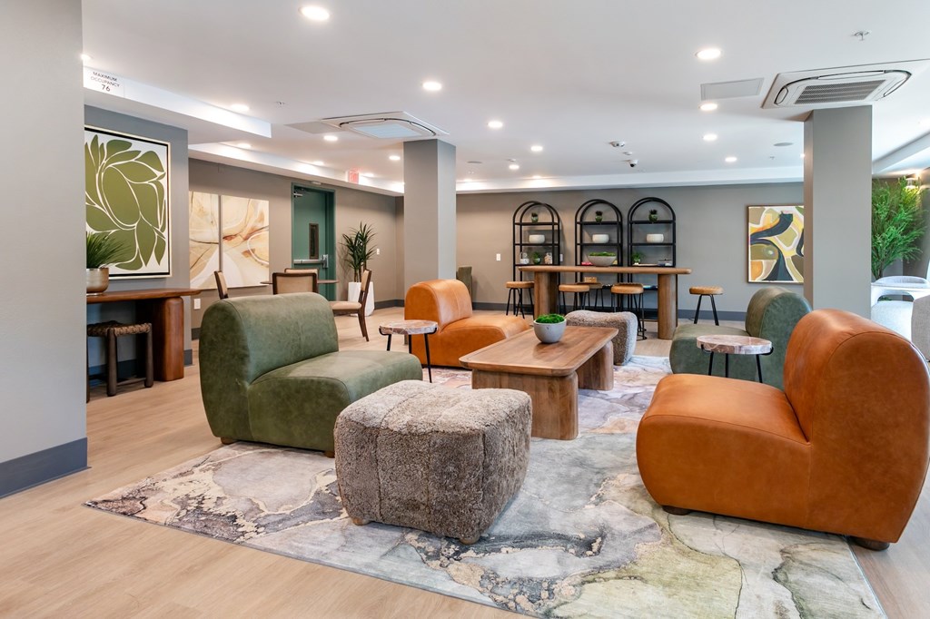 A living room with a green and orange chair, a grey ottoman, and a rug with a map design.