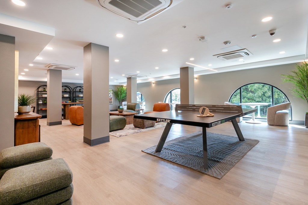 A spacious living room with a large table and chairs.