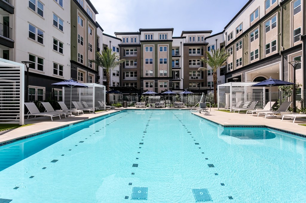 A large swimming pool in front of apartment buildings.