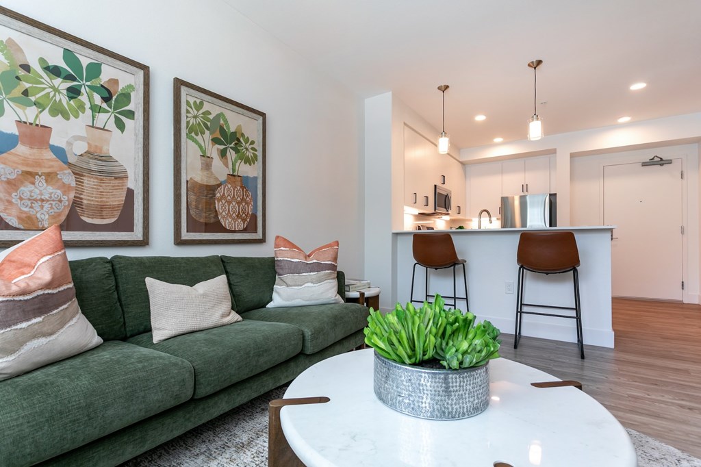 A living room with a green couch and a white coffee table.