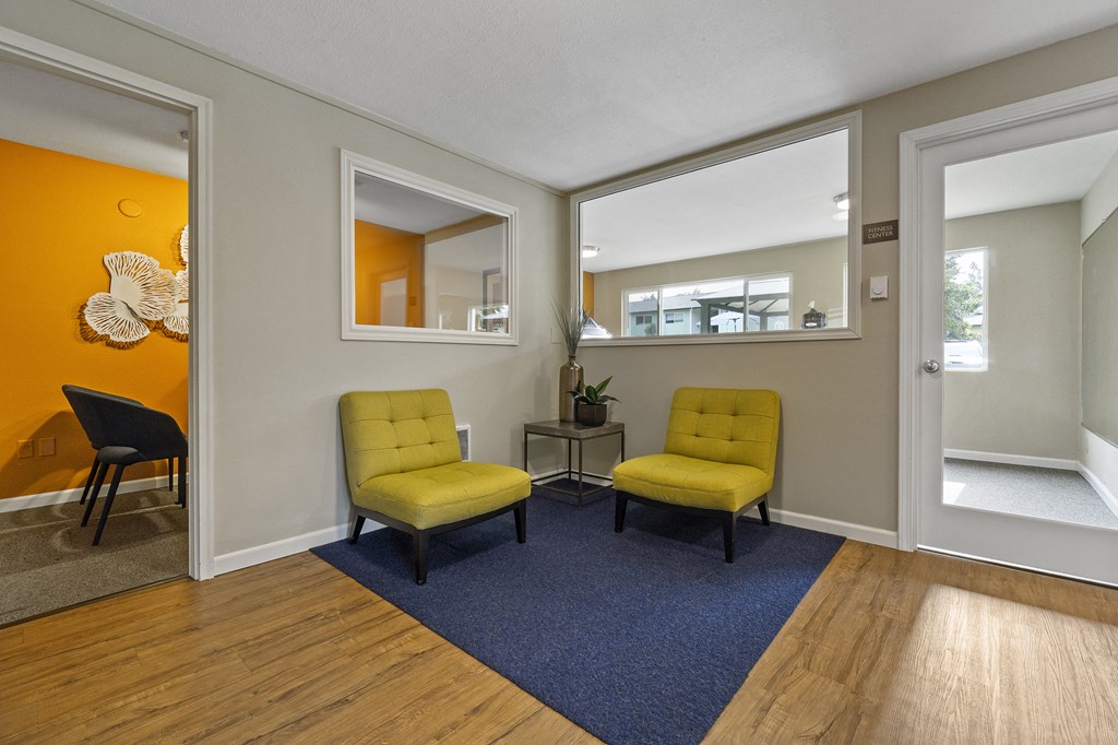 a living room with yellow chairs and a blue rug