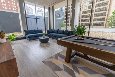 A pool table in a room with a view of the city.