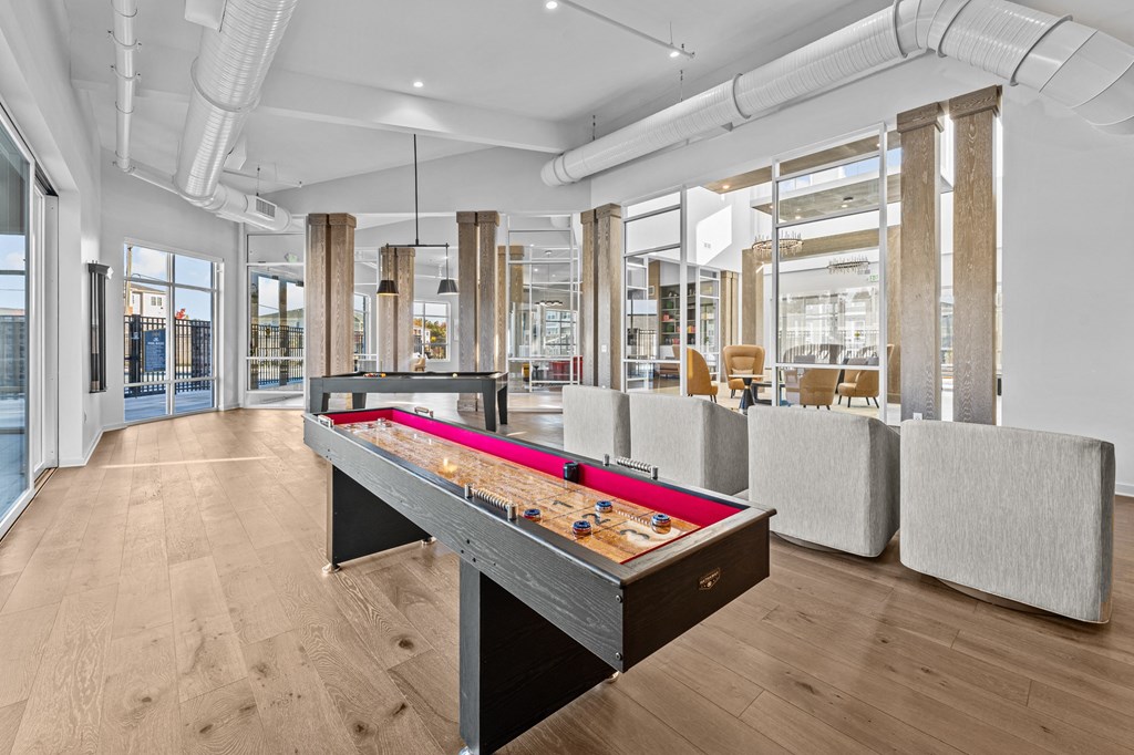 a games room with a ping pong table and couches