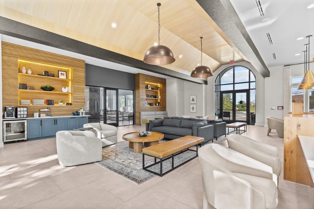 A modern living room with a large window and a kitchen area.