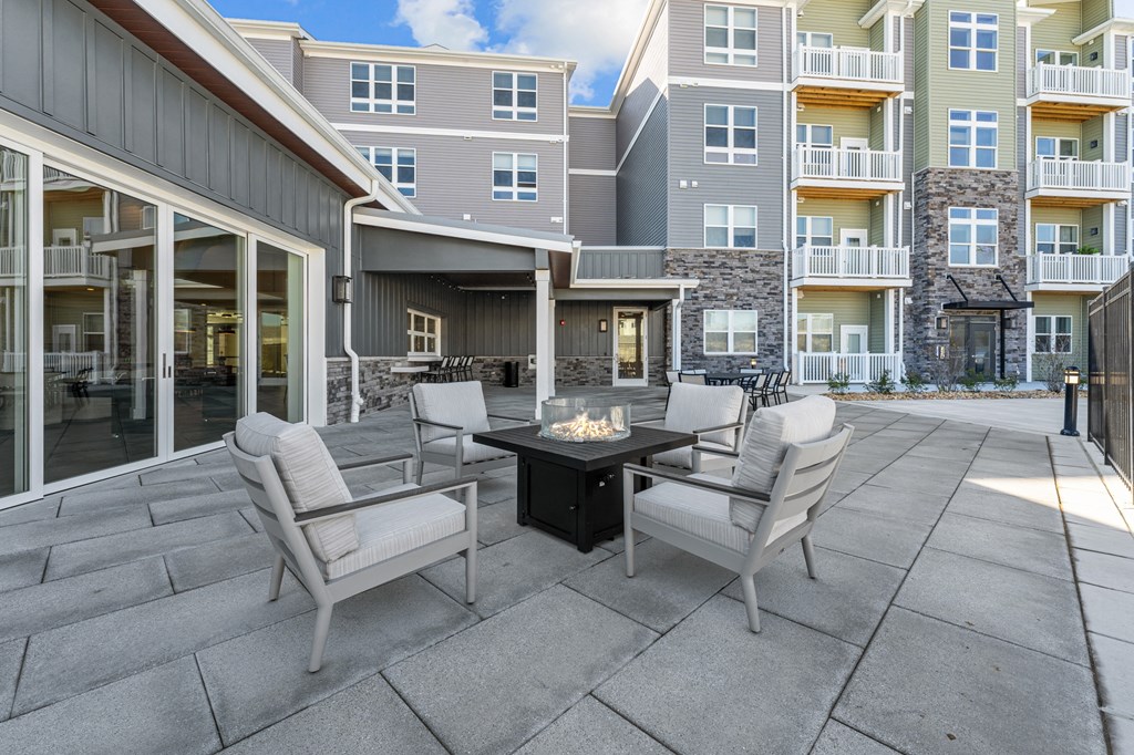 an outdoor patio with chairs and a fire pit
