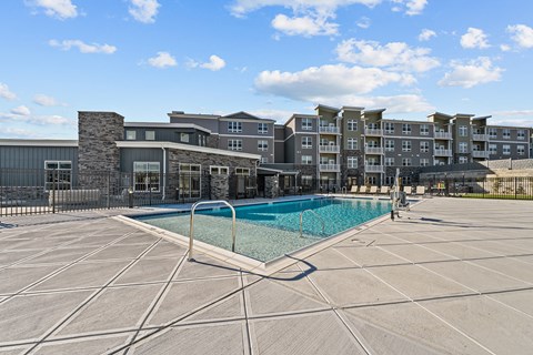 a swimming pool with an apartment building in the background