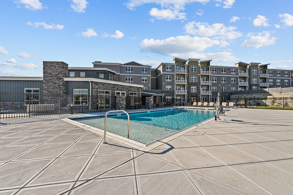 a swimming pool with an apartment building in the background