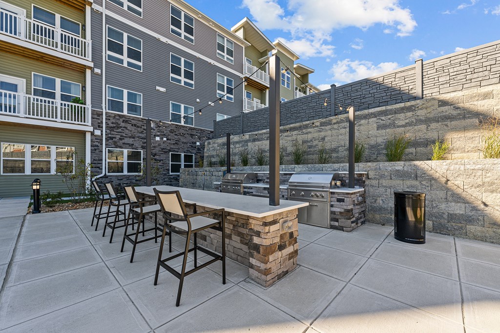 an outdoor patio with a grill and a table with chairs