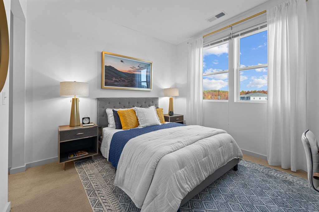 a bedroom with a bed and two windows