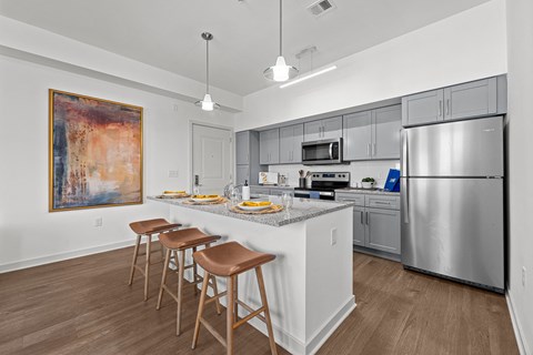 a kitchen with stainless steel appliances and a counter with three stools
