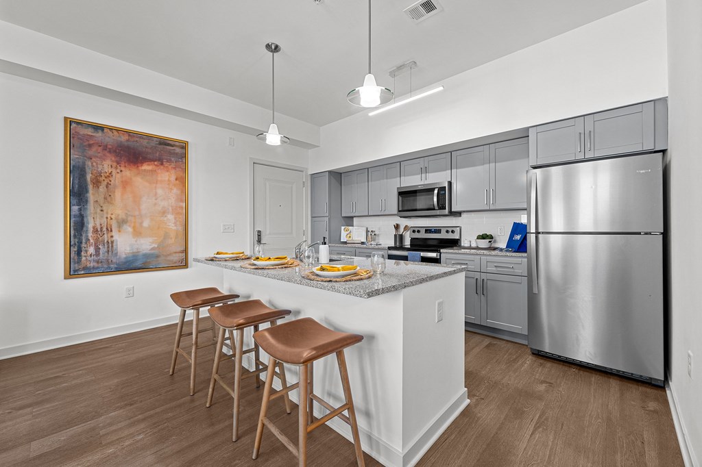 a kitchen with stainless steel appliances and a counter with three stools