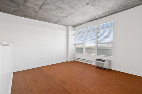 A room with a window and a wall-mounted air conditioner.
