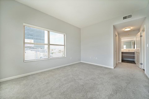 a living room with a large window and a carpeted floor