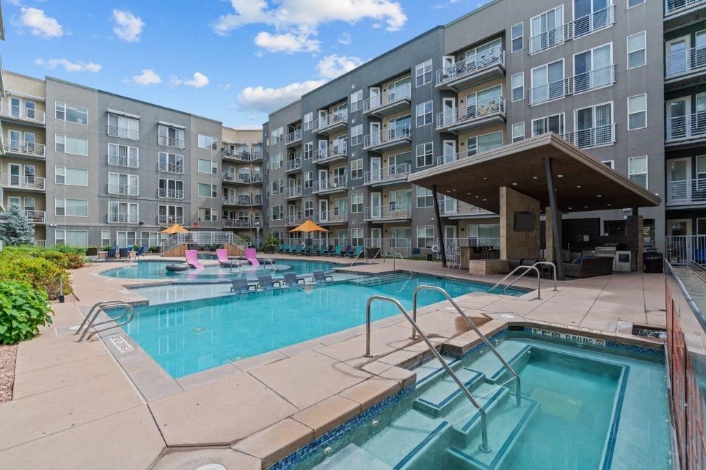 a swimming pool and hot tub in front of an apartment building