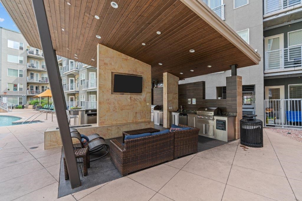a covered patio with a kitchen and a pool