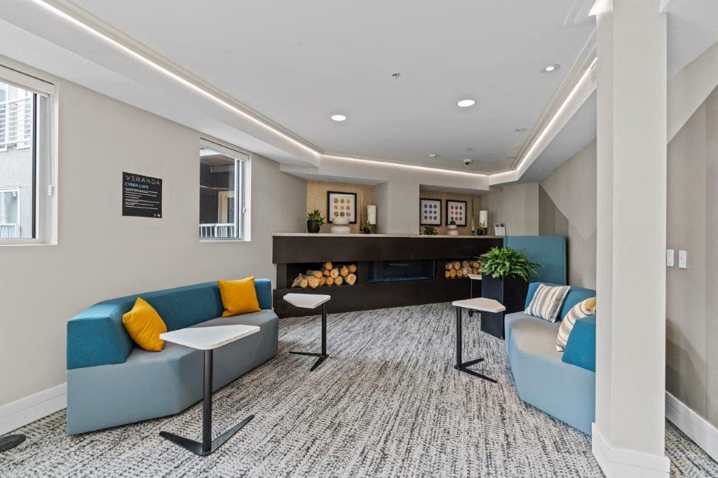 a lobby with blue couches and yellow and blue pillows