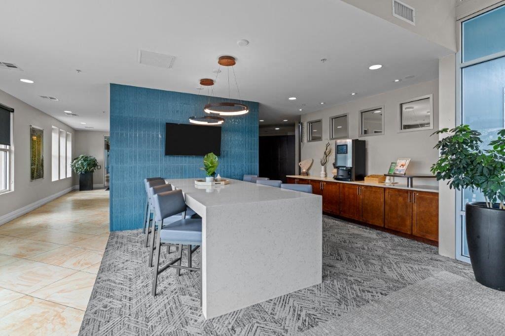 a long white table with chairs in front of a blue wall