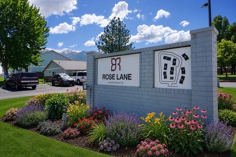 Rose Lane Apartments sign with a landscaped garden in front.
