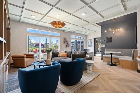 A modern living room with blue chairs and a wooden floor.